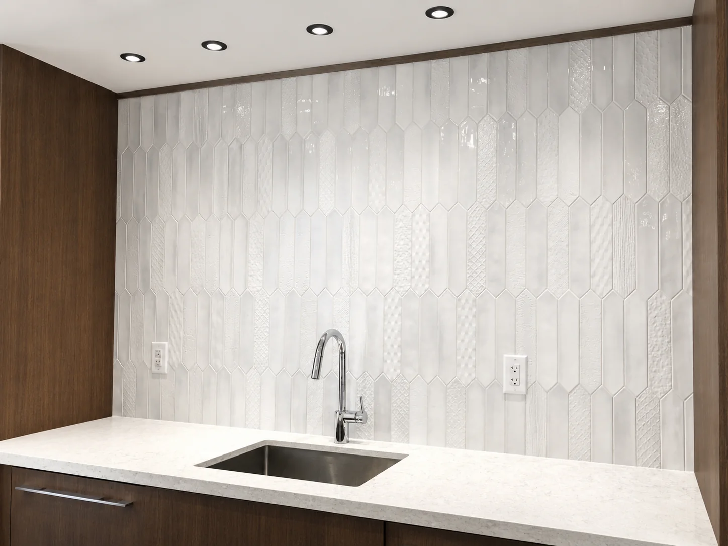 White elongated hex tile kitchen backsplash with clean grout and countertop detail